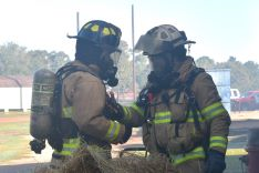 Two fire academy students talking while in bunker gear